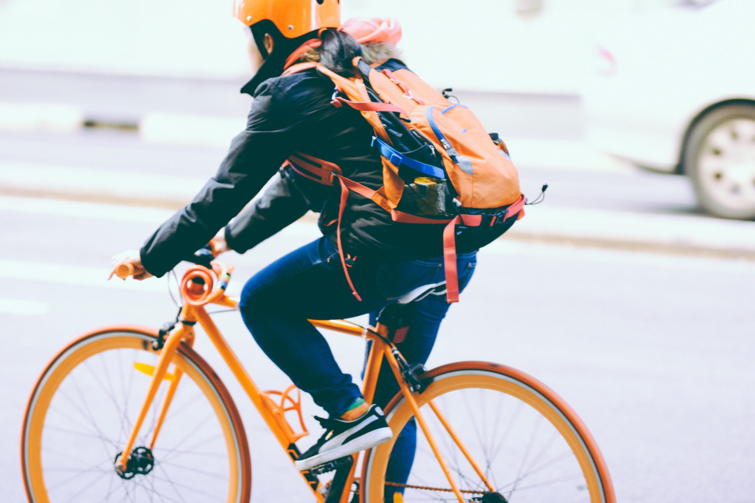 Bilden visar en person som cyklar till jobbet. Låsbara cykelställ till cykelparkeringar och cykelrum har blivit allt viktigare då cykeln fått en ökad betydelse som transportmedel.